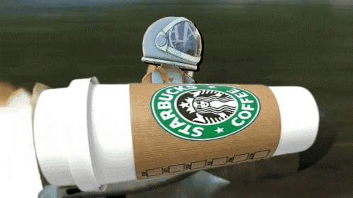 a starbucks coffee cup with a spaceman on top of it