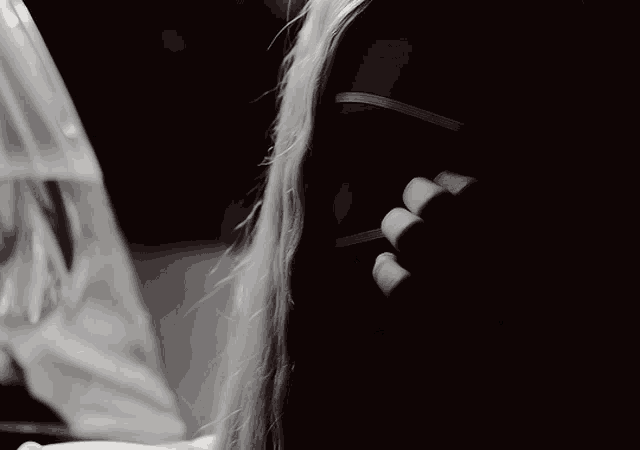 a woman wearing a mask covering her face looks out a window
