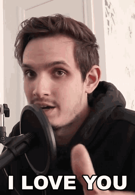 a man in front of a microphone with the words i love you above him