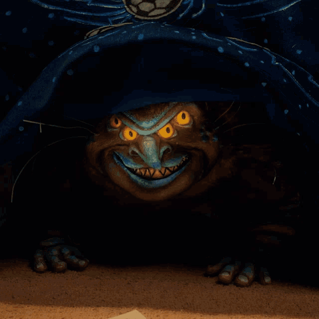 a blue blanket with soccer balls on it has a monster sticking out its tongue