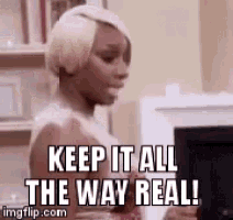 a woman is sitting in front of a computer with the words `` keep it all the way real '' written on it .