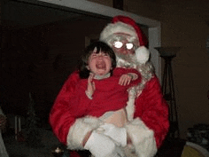 a man in a santa suit is holding a little girl who is crying .