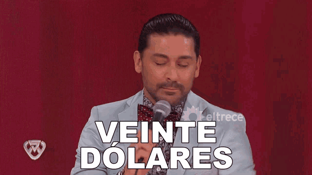 a man in a suit and bow tie is speaking into a microphone with the words veinte dolares above him