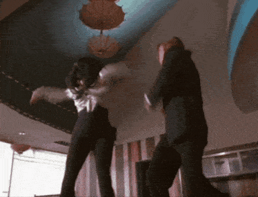 a man in a suit is fighting a woman in a white shirt