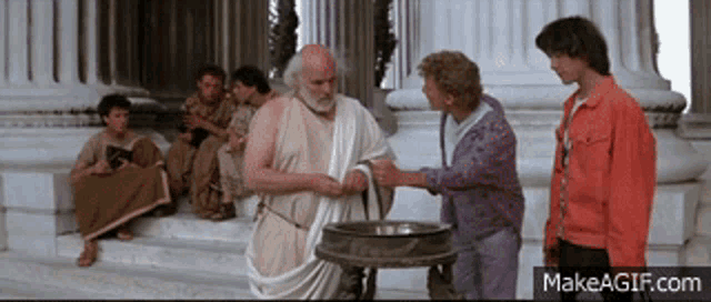 a man in a toga shakes hands with another man in front of a group of people