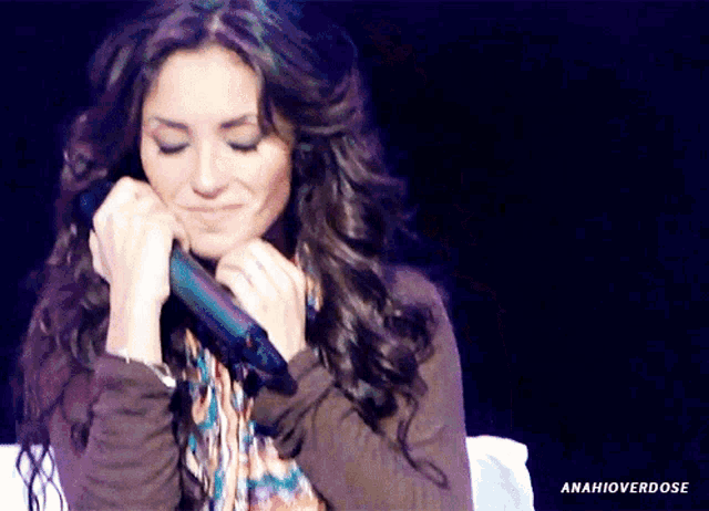 a woman holding a microphone with the hashtag amahioverdose