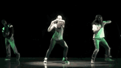 a group of people are dancing on a stage and one of them has the number 4 on their shirt