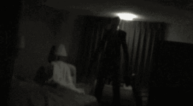 a silhouette of a man in a suit standing in a dark room