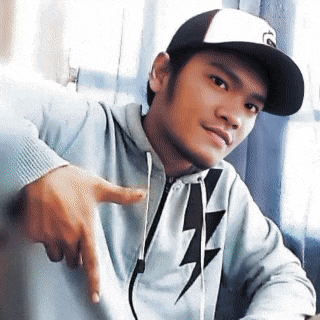 a young man wearing a hat and a lightning bolt hoodie is pointing at something .