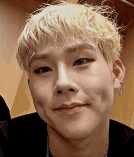 a close up of a person 's face with blonde hair and earrings