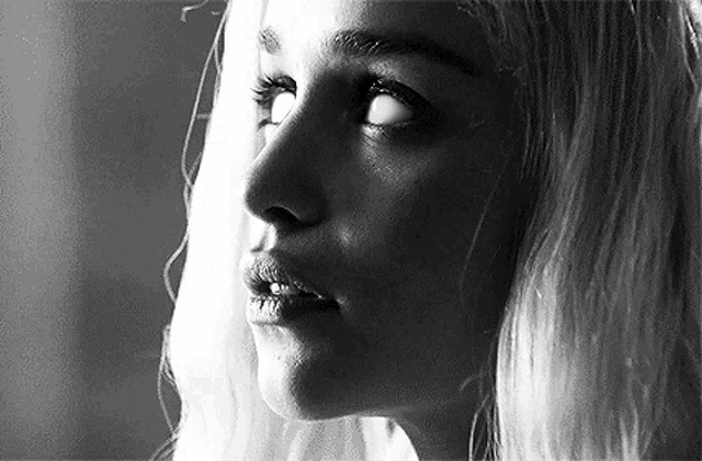 a black and white photo of a woman 's face with a serious look on her face .