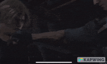 a person 's feet are shown in a dark room with the word kapwing in the lower right corner