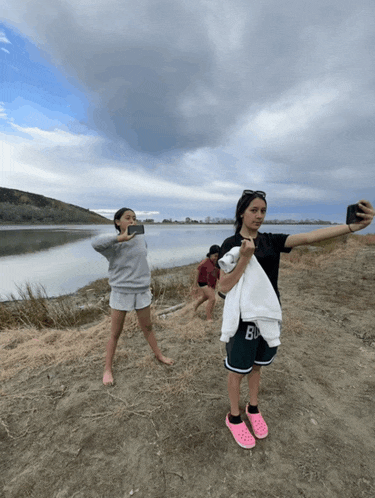 a girl taking a selfie with a towel that says bu