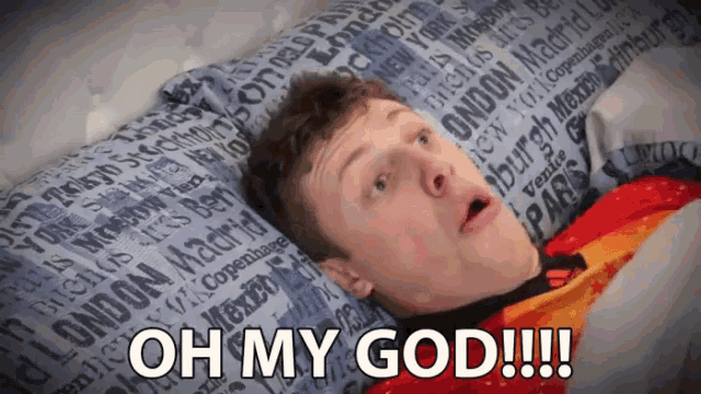 a man laying on a bed with a pillow that says " oh my god " on it