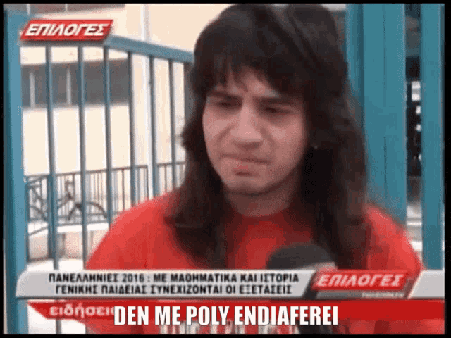 a man with long hair and a red shirt is being interviewed on a greek news channel