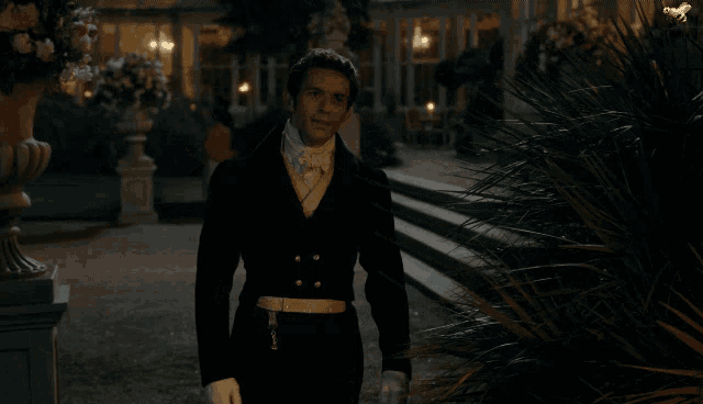 a man in a suit stands in front of a house