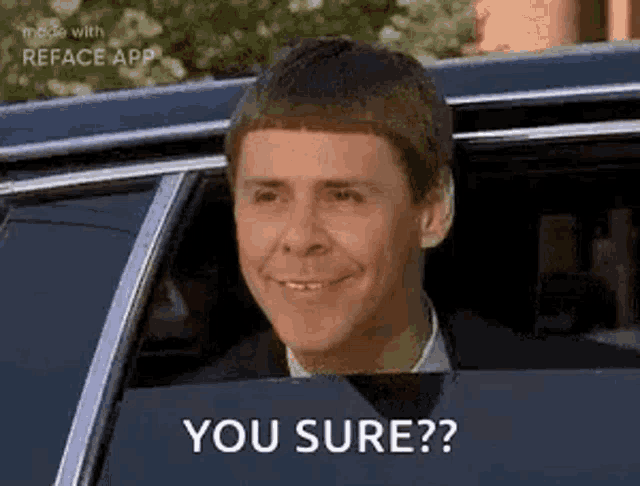 a man is sitting in a car with his head out the window and smiling .