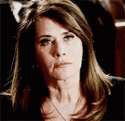 a woman with long brown hair is wearing a black shirt and a necklace .
