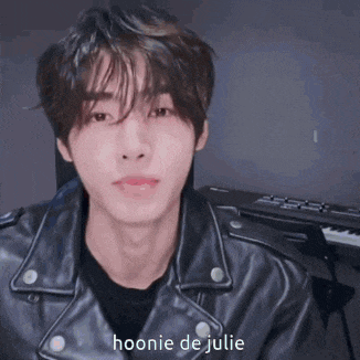 a young man wearing a black leather jacket with hoonie de julie written on it