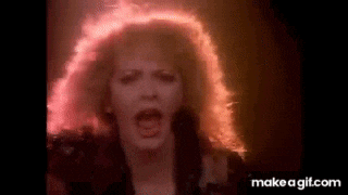 a woman with red hair is screaming into the camera .