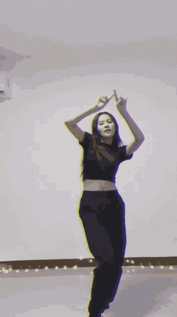 a woman in a crop top and black pants is dancing