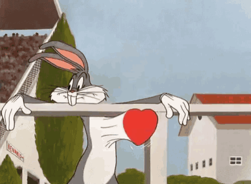 bugs bunny is holding a heart in his hand while leaning over a railing