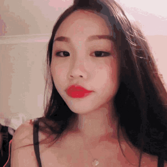 a close up of a woman 's face with long hair and red lips