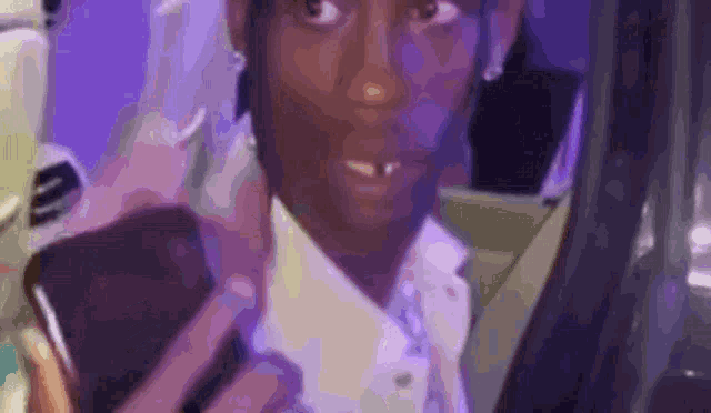a man in a suit is holding a cell phone and looking at the camera .