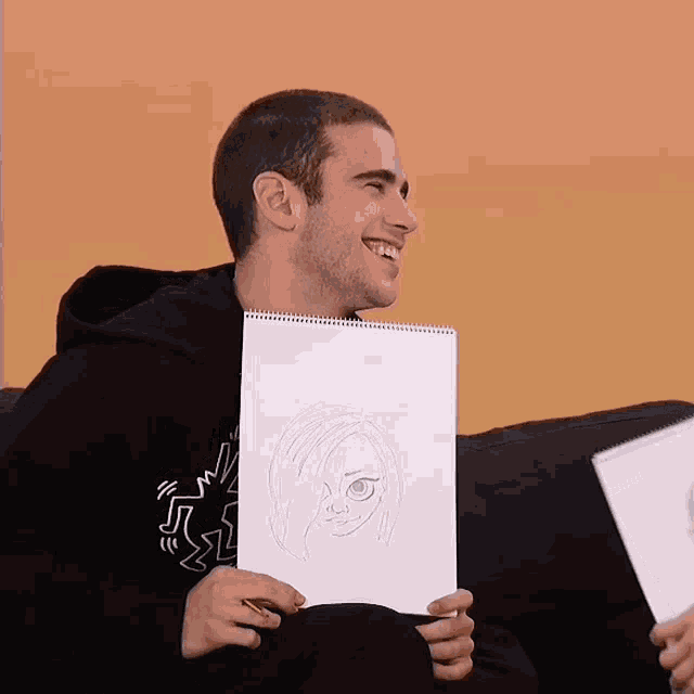 a man is holding a drawing of a girl with a smiley face