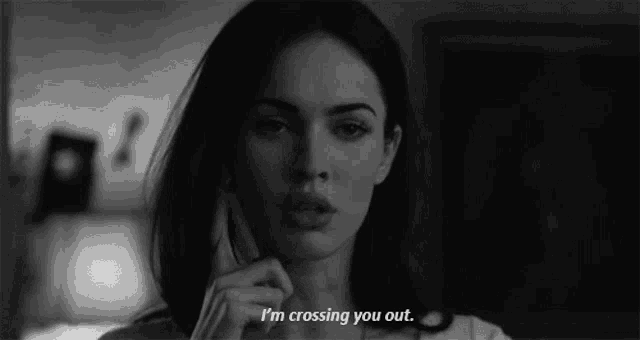 a black and white photo of a woman talking on a cell phone with the words i 'm crossing you out .