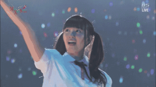 a girl with pigtails is dancing on a stage with a bs live logo in the corner