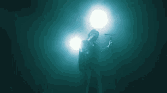 a man is singing into a microphone in a dark room .