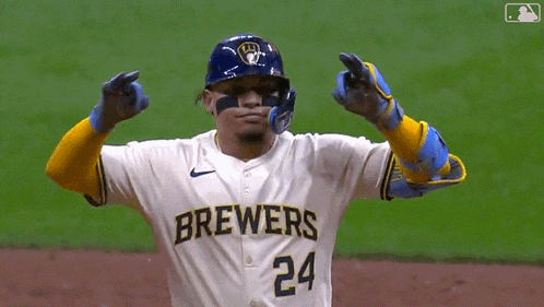 a baseball player wearing a brewers jersey and gloves