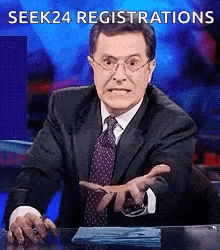 a man in a suit and tie is sitting at a desk with the words " seek24 registrations " written above him