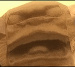 a close up of a piece of brown paper with a hole in it