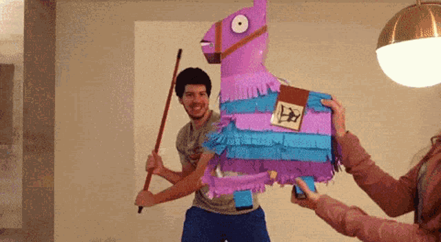 a man and a woman are holding a piñata that looks like a llama