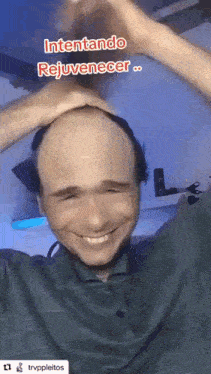 a man is smiling and making a heart shape with his hands on his head