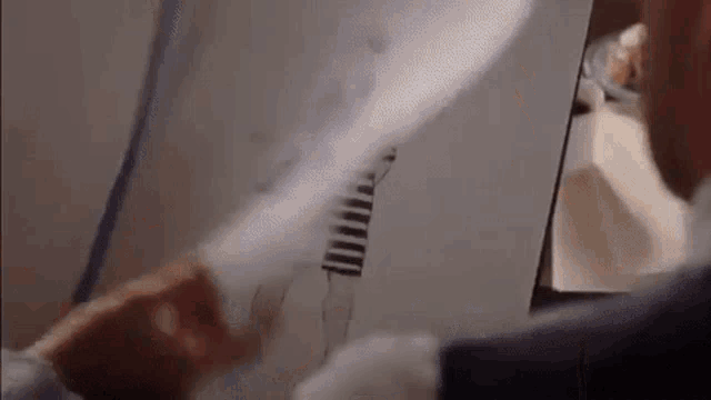 a man in a suit is holding a piece of paper with a picture of a zebra on it .