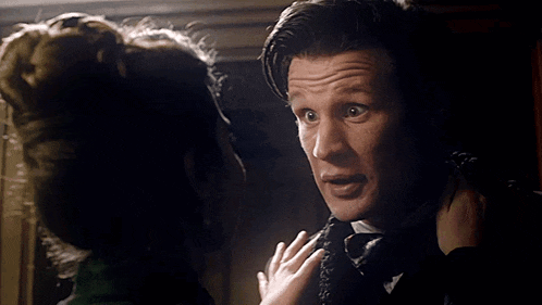 a man and a woman are looking at each other and the woman is holding the man 's neck