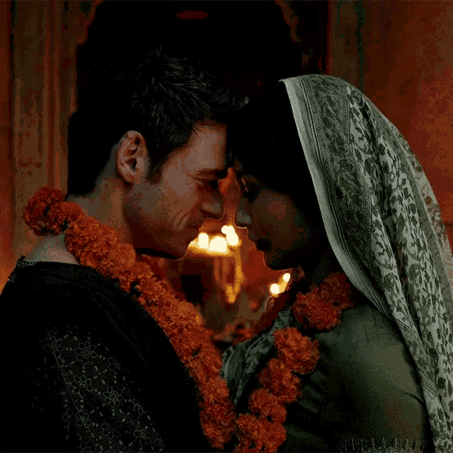 a man and a woman are touching their noses in a dark room