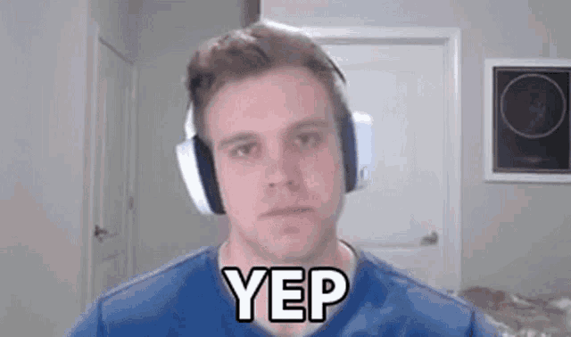 a man wearing headphones and a blue shirt is making a funny face and saying yep .