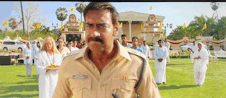 a man in a police uniform is standing in a field with a group of people .