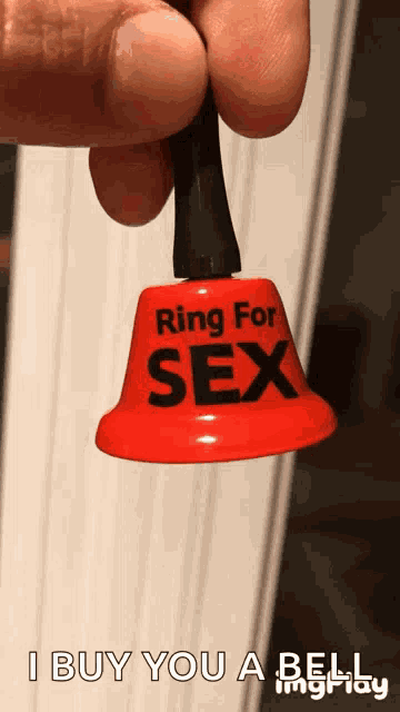 a bell that says ring for sex is being held in someone 's hand