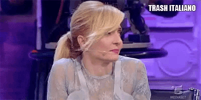 a woman is sitting in front of a microphone with the words trash italiano written above her .