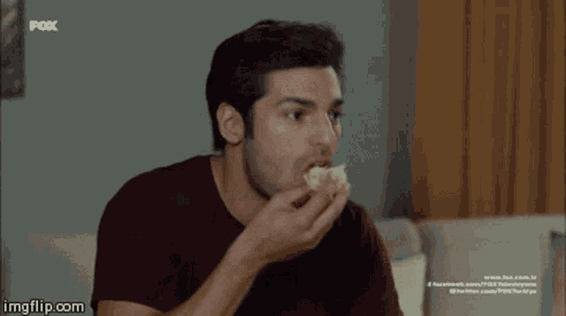 a man sitting on a couch with a fox logo on the bottom right