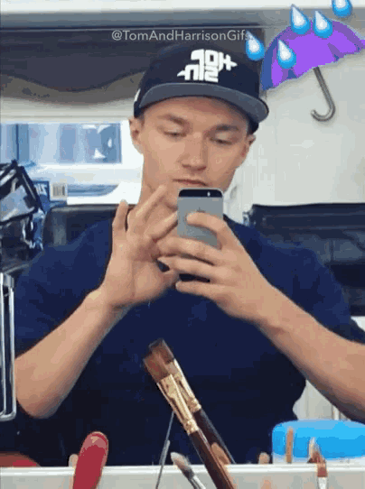 a man in a hat is taking a selfie with his phone