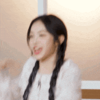a blurry picture of a woman with pigtails and a white shirt .