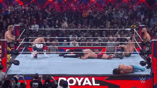 a group of wrestlers are fighting in a wrestling ring .