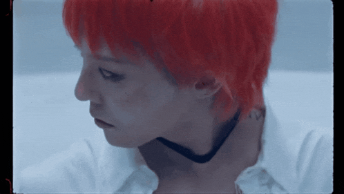 a person with red hair is wearing a white shirt