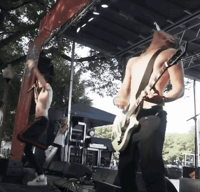 a man playing a guitar and a man singing on stage